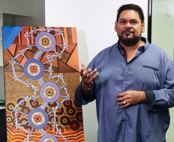 Person standing next to a painting.