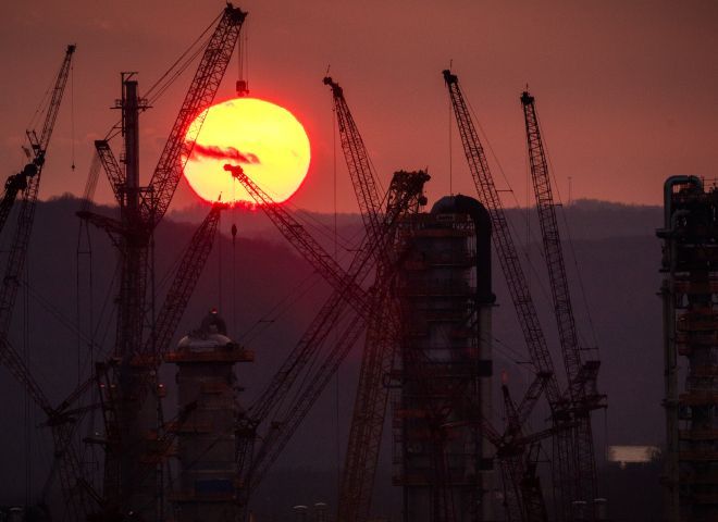 Silhoutte of cranes in front of a sunset.