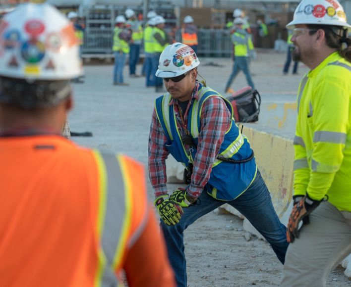 Bechtel team members in safety gear stretching.