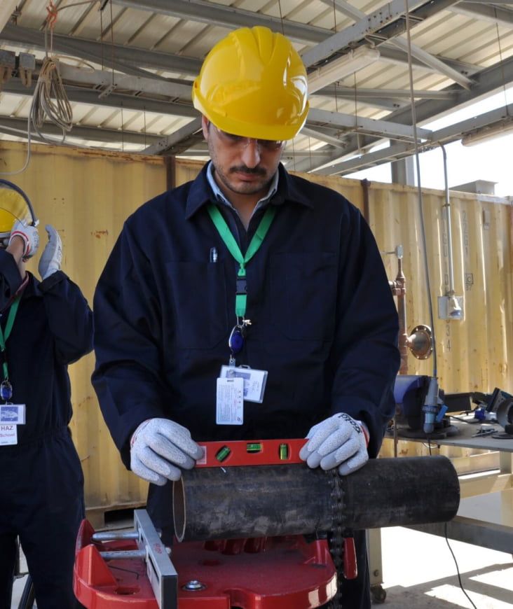 Person wearing a hard hat using a level.