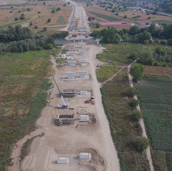 Aerial view of dirt road with construction underway in the Morava Corridor.