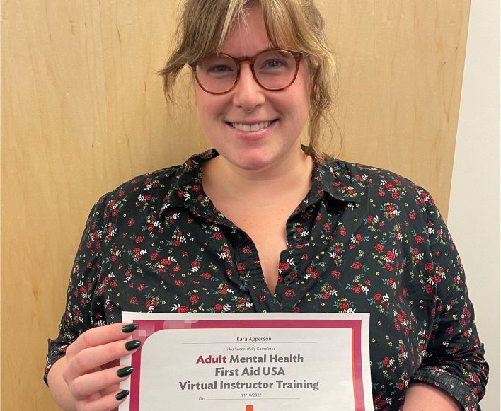 Bechtel employee Kara Apperson holding certificate of completion for Adult Mental Health First Aid USA Virtual Instructor training.
